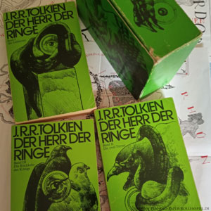 Achtzehnte Auflage der kartonierten Sonderausgabe von Der Herr der Ringe aus der Verlagsgemeinschaft Ernst Klett Verlag - J. G. Cotta'sche Buchhandlung. Roman Der Herr der Ringe: drei Bände mit grünem Softcover und etwas Kartenmaterial in einer Box