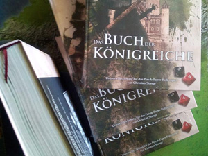 Die Aufnahme zeigt vier Exemplare der 1. Auflage des Kompendiums DAS BUCH DER KÖNIGREICHE