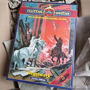 Kartoniertes Box SET MERS-Zweitauflage von Queen Games mit dem Titelmotiv Gandalfs, der die Horden Mordors vor Minas Tirith aufhält.