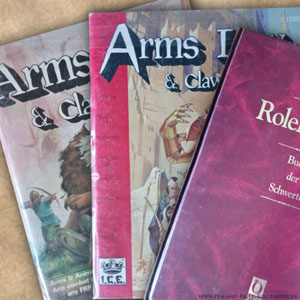 Auf dem Bild sind drei Versionen des Arms Law & Claw Law - Buch der Schwerter der Jahre 1984 bis 1994 zu sehen.