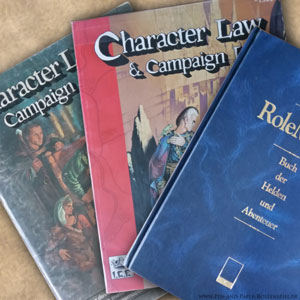 Das Foto zeigt das Character Law & Campaign Law mit der deutschen Ausgabe Das Buch der Helden und Abenteuer der zweiten Edition von Rolemaster.