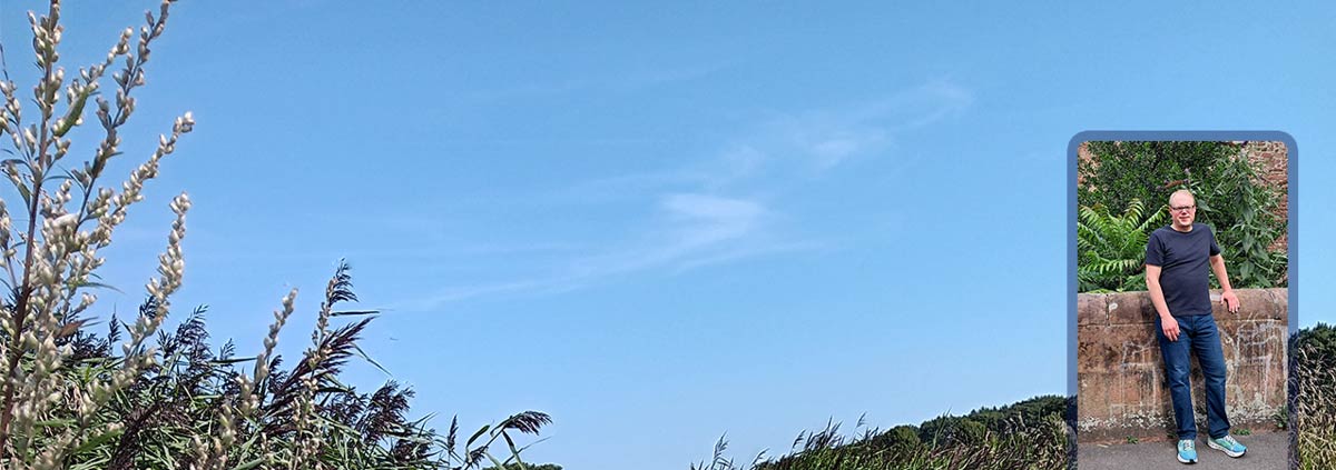 Blauer Himmel über dem grünen Ufer der Schlei, darüber gelegt ein Foto von Christian Stange